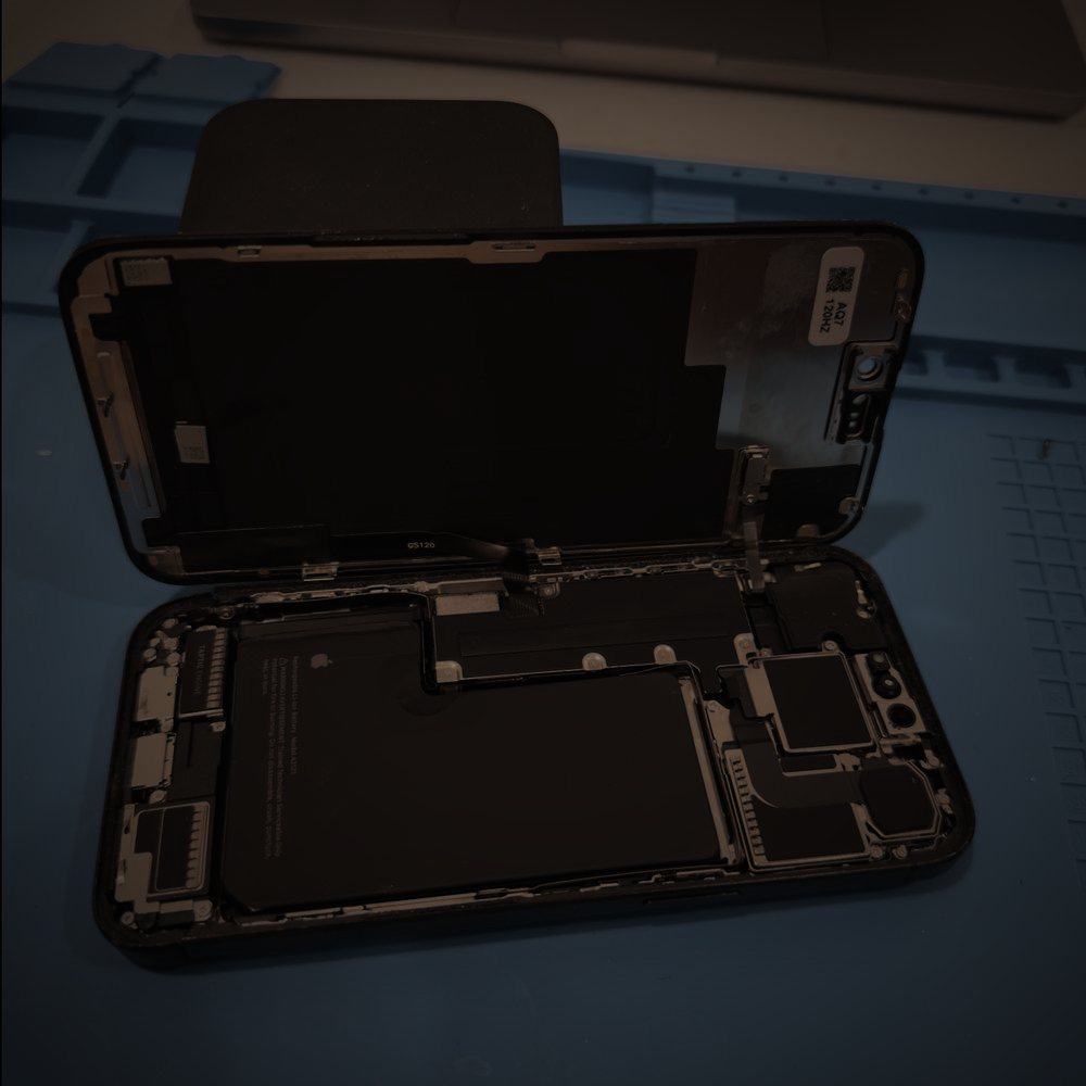 An iPhone opened on the repair mat with the display hinged back